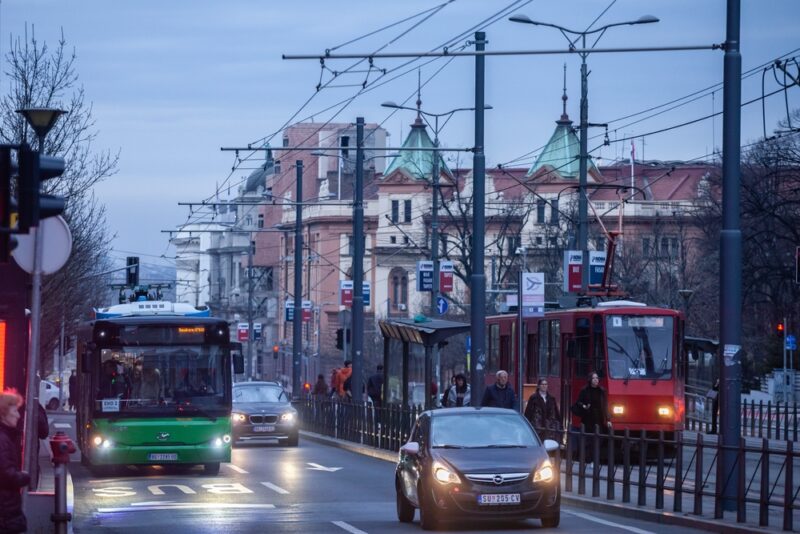 Ulica u Beogradu sa tramvajem, autobusom i automobilima u gustoj saobraćajnoj gužvi